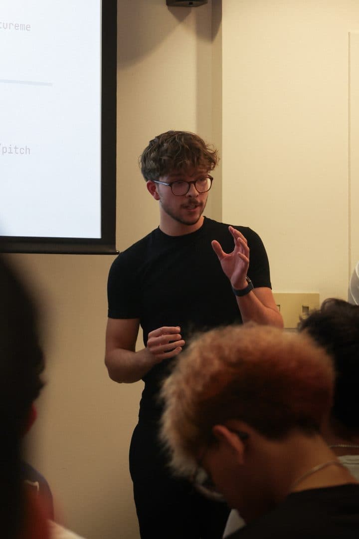 A board member talking in front of the projector screen.