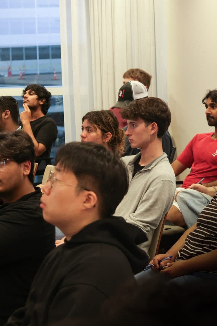 Students listening from their seats by the window.